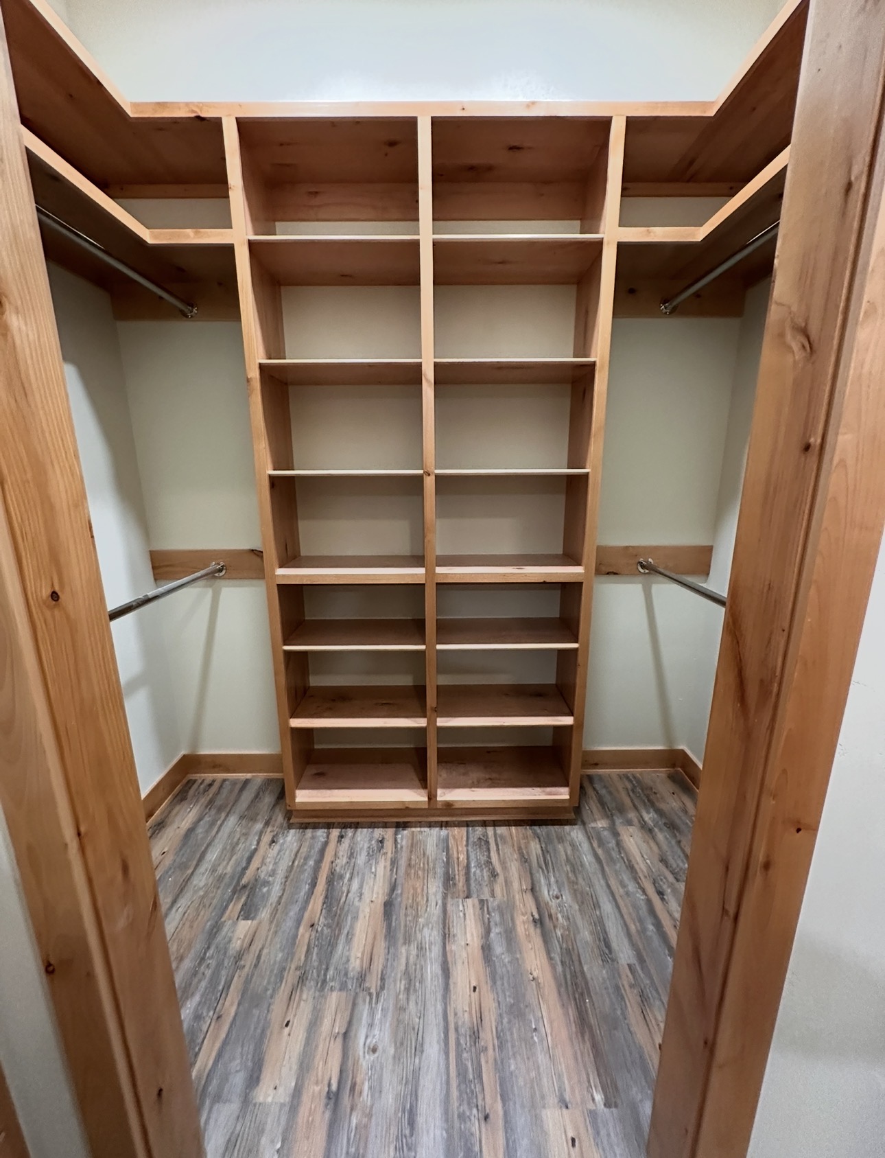 Custom wood shelving and hanging storage in a walk-in closet